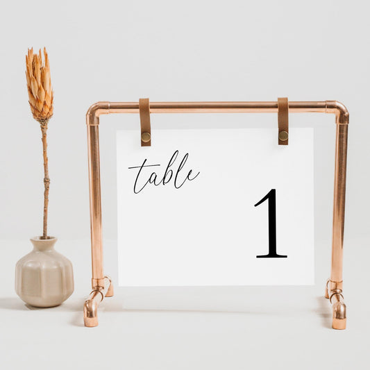 Horizontal table number sign on a frame, with the text &#39;table&#39; in a minimalist script font and the number 1.